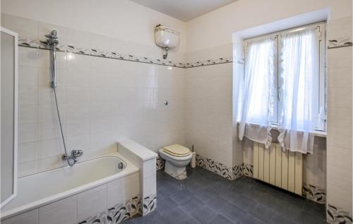 a bathroom with a tub and a toilet and a sink at 5 Bedroom Beautiful Home In Giove in Giove