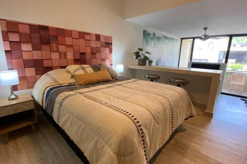 a bedroom with a large bed and a kitchen at Syrena 401 y 606 in Playa del Carmen