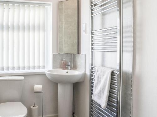 a bathroom with a sink and a toilet and a mirror at The Dairymans Cottage in York