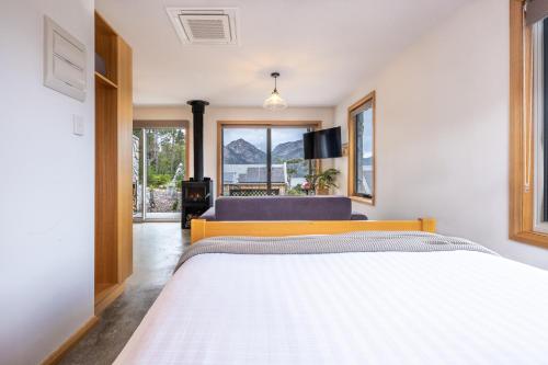 a bedroom with a large white bed and a window at Freycinet Stone Studio 7 - Quartz in Coles Bay
