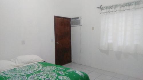 a bedroom with a bed and a wooden door at Departamento CUARTITO MODESTO DEL PRECIOSO in Martínez de La Torre