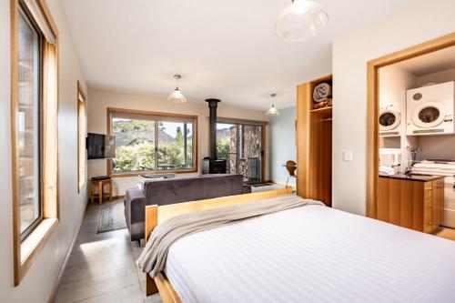 a bedroom with a large bed and a kitchen at Freycinet Stone Studio 4 - Granite in Coles Bay