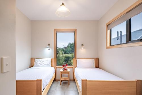 2 camas en una habitación con ventana en Freycinet Stone Studio 5 - Greystone, en Coles Bay