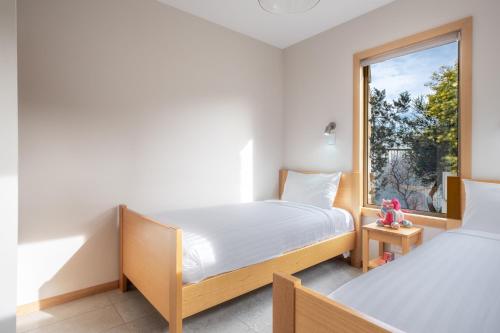 - 2 lits dans une chambre avec fenêtre dans l'établissement Freycinet Stone Studio 3 - Feldspar, à Coles Bay
