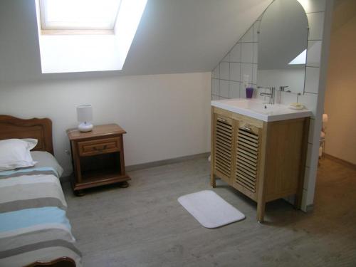 a bathroom with a sink and a mirror and a bed at Maison rénovée près de la Forêt de Tronçais, grand jardin, cheminée, wifi, animaux acceptés - FR-1-489-128 in Urçay