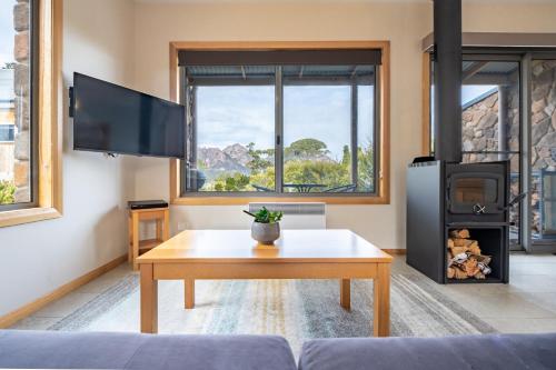 a living room with a coffee table and a tv at Freycinet Stone Studio 4 - Granite in Coles Bay
