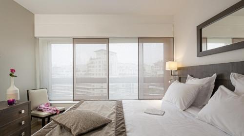 a bedroom with a large bed and a large window at Residhome Courbevoie La Défense in Courbevoie