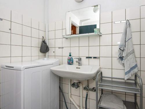 uma casa de banho branca com um lavatório e um espelho em Holiday home Struer XXV em Struer