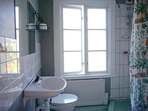 a bathroom with a sink and a toilet and a window at Holiday home RONNEBY IX in Ronneby