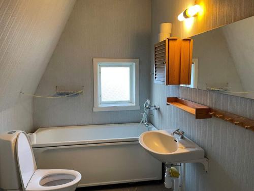 a bathroom with a toilet and a sink and a tub at Holiday home LJUSDAL III in Ljusdal