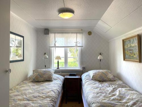 a bedroom with two beds and a window and a desk at Holiday home GRÄSTORP in Grästorp