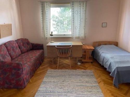 a living room with a couch and a bed and a window at Holiday home LJUSDAL III in Ljusdal