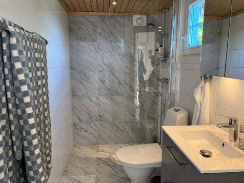 a bathroom with a shower and a toilet and a sink at 4 person holiday home in INGARÖ-By Traum in Grönskan