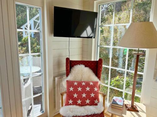 a room with a chair with a pillow and a television at 4 person holiday home in INGARÖ-By Traum in Grönskan