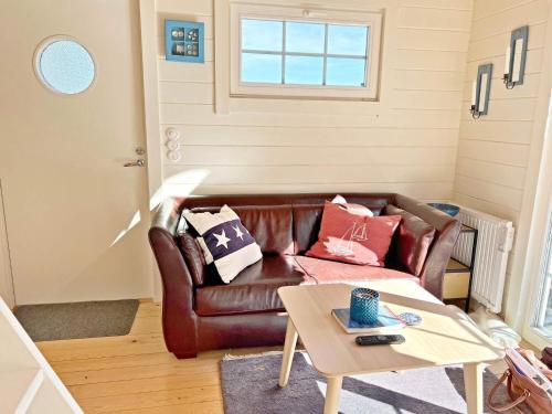 a living room with a brown leather couch and a table at 4 person holiday home in INGARÖ-By Traum in Grönskan