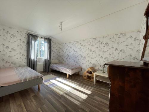 a bedroom with two beds and a desk and a window at 6 person holiday home in BRUZAHOLM-By Traum in Bruzaholm