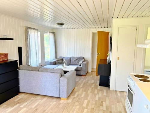 a living room with a couch and a table at Holiday home VÄDDÖ VI in Väddö