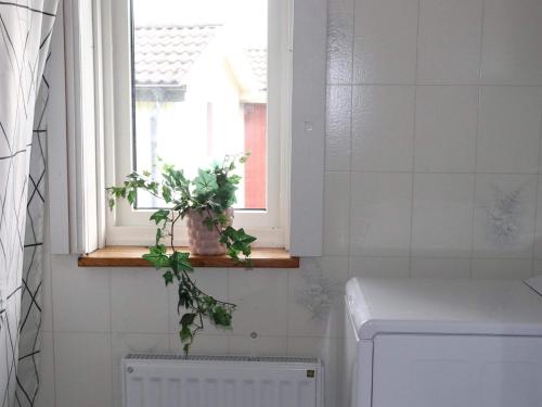 a bathroom with a window and a plant on a window sill at Holiday home Tvååker III in Tvååker