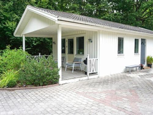 a white house with a chair on a patio at 4 person holiday home in LYCKEBY-By Traum in Lyckeby