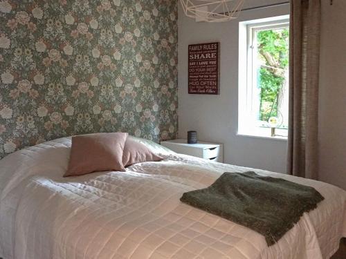 een bed met een deken en een raam in een slaapkamer bij Holiday home LYCKEBY III in Lyckeby
