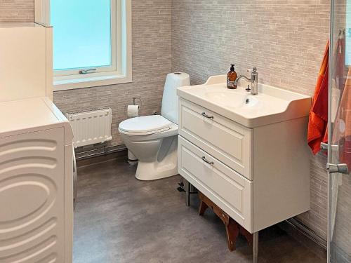 La salle de bains blanche est pourvue de toilettes et d'un lavabo. dans l'établissement Holiday home RIMFORSA VI, à Rimforsa
