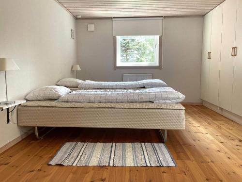 1 dormitorio con 2 camas y ventana en Holiday home GAMLEBY VI, en Gamleby