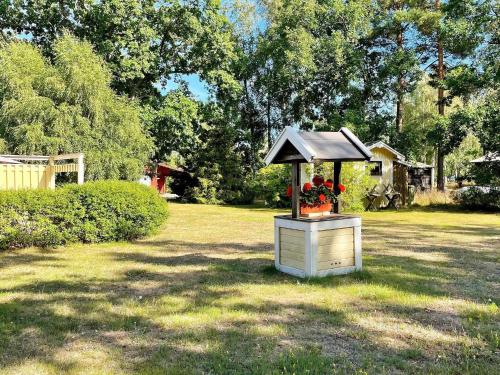 a bird feeder with a roof on a yard at 7 person holiday home in Hagby-By Traum in Hagby