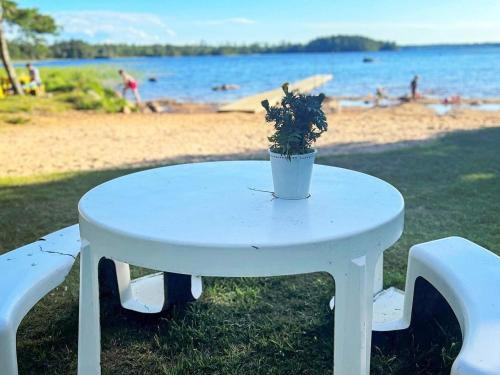 a white table with a potted plant on a beach at 8 person holiday home in Annerstad-By Traum in Skärseryd