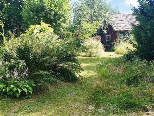 a garden with plants and a house in the background at 8 person holiday home in Annerstad-By Traum in Skärseryd