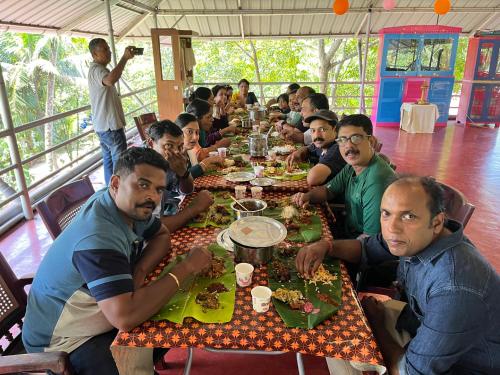 a group of men sitting at a table eating food at Marari Beach Villas in Mararikulam