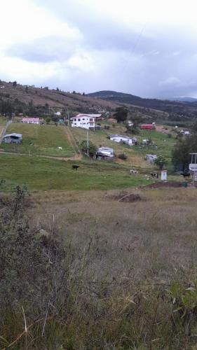 a grassy field with a town in the background at Cabañas Casa Campo Guatavita in Guatavita