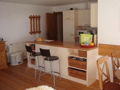 eine Küche mit einer Theke und Hockern in einem Zimmer in der Unterkunft Ferienwohnung Maria im Landhaus Christina in Alpbach