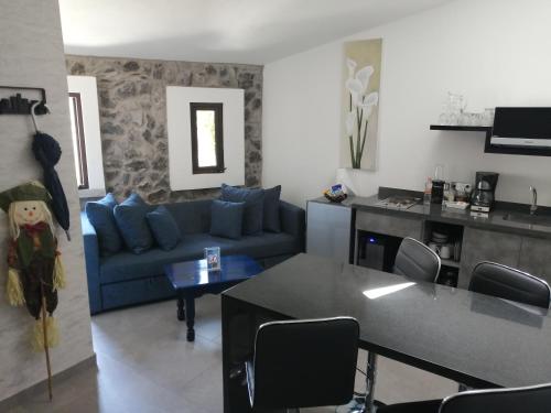 a living room with a blue couch and a kitchen at Loft en Centro de Val'Quirico Volterra hotel in Santeagueda