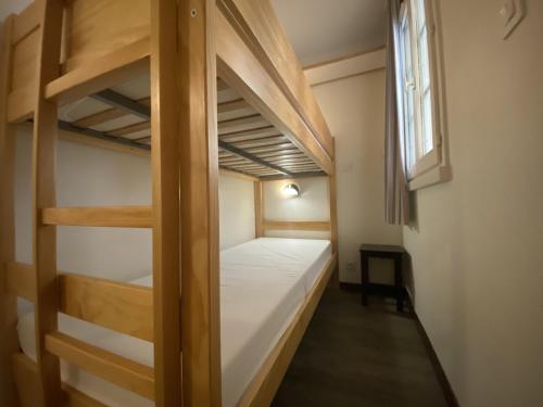 une chambre avec deux lits superposés et une fenêtre dans l'établissement Studio cosy à 5 min du port et de la plage, avec terrasse et parking - 4 pers - FR-1-639-78, à Arzon