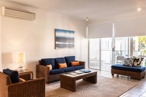 a living room with two couches and a table at Beaches Holiday Apartments - Official Onsite Reception & Check In in Port Douglas