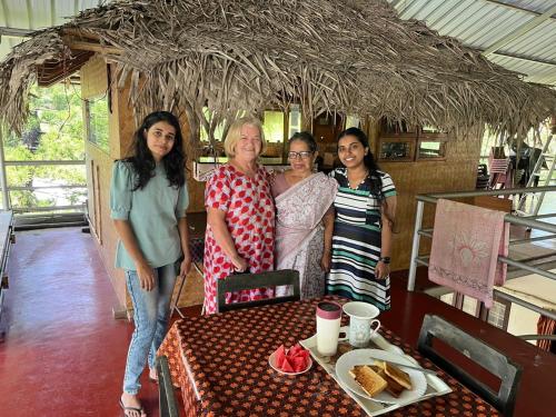 a group of three women standing next to a table at Marari Beach Villas in Mararikulam