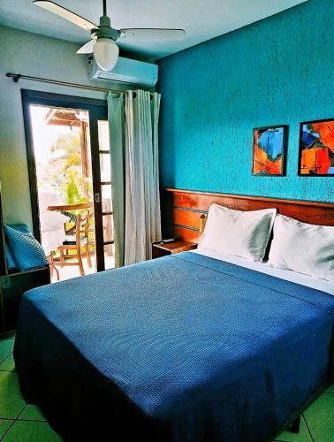 a blue bedroom with a bed and a ceiling fan at Pousada Aquarela do Mar in Abraão