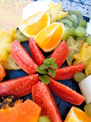 a plate of fruit and vegetables on a table at Pousada Aquarela do Mar in Abraão