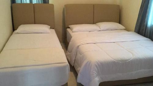 2 Betten nebeneinander in einem Zimmer in der Unterkunft Villa Seagull Lot 1239 in Kampong Alor Gajah