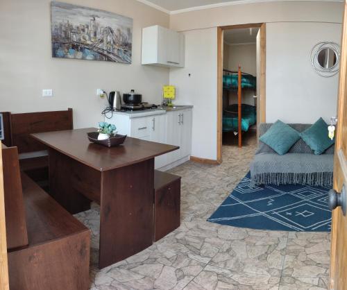 a kitchen and living room with a table and a couch at Departamentos Entre Lagos in Licán Ray