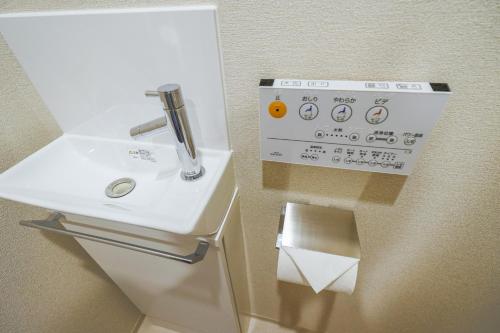 een badkamer met een wastafel en een rol toiletpapier bij HIZ HOTEL - Vacation STAY 08955v in Tokyo