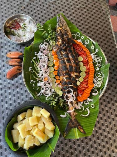 a plate of food with carrots and other vegetables at Marari Beach Villas in Mararikulam