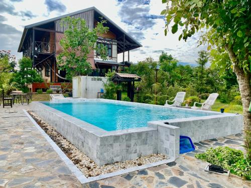 een zwembad voor een huis bij Rang Robin Farmstay with swimming pool in Ban Wang Muang