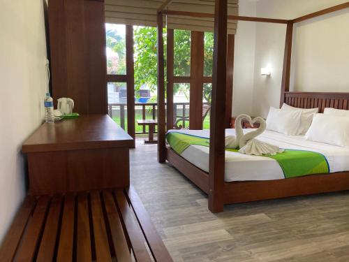 a bedroom with two beds and a desk with a swan on it at Handagedara Resort & Spa in Mirissa