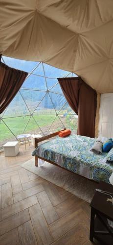 Domo Glamping Monteverde في مونتيفيردي كوستاريكا: غرفة نوم بسرير مع خيمة كبيرة