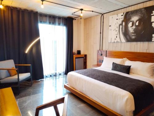 - une chambre avec un lit king-size et une chaise dans l'établissement Hotel Tila, à Cholula
