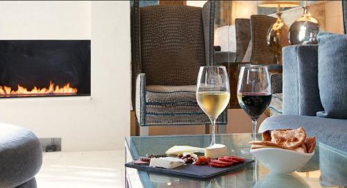 une table en verre avec deux verres de vin et de fromage dans l'établissement Hotel Veritas, à Cambridge