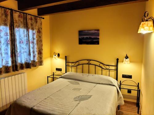 um quarto com uma cama com paredes amarelas em Cal Teler-Rufiandis em Olopte