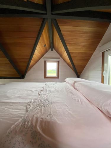 a large white bed in a room with a window at Tiny House, La Candelaria in Luján