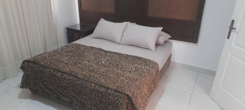 Delta Sharm appartment Shahrazad في شرم الشيخ: سرير مع بطانية بنية ومخدات في الغرفة